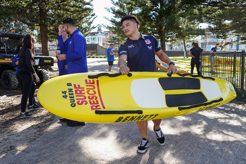 Ronald Volkman assists by moving a Surf Rescue Board.
